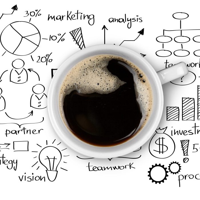 Top view of cup of delicious hot coffee on charts and business doodles